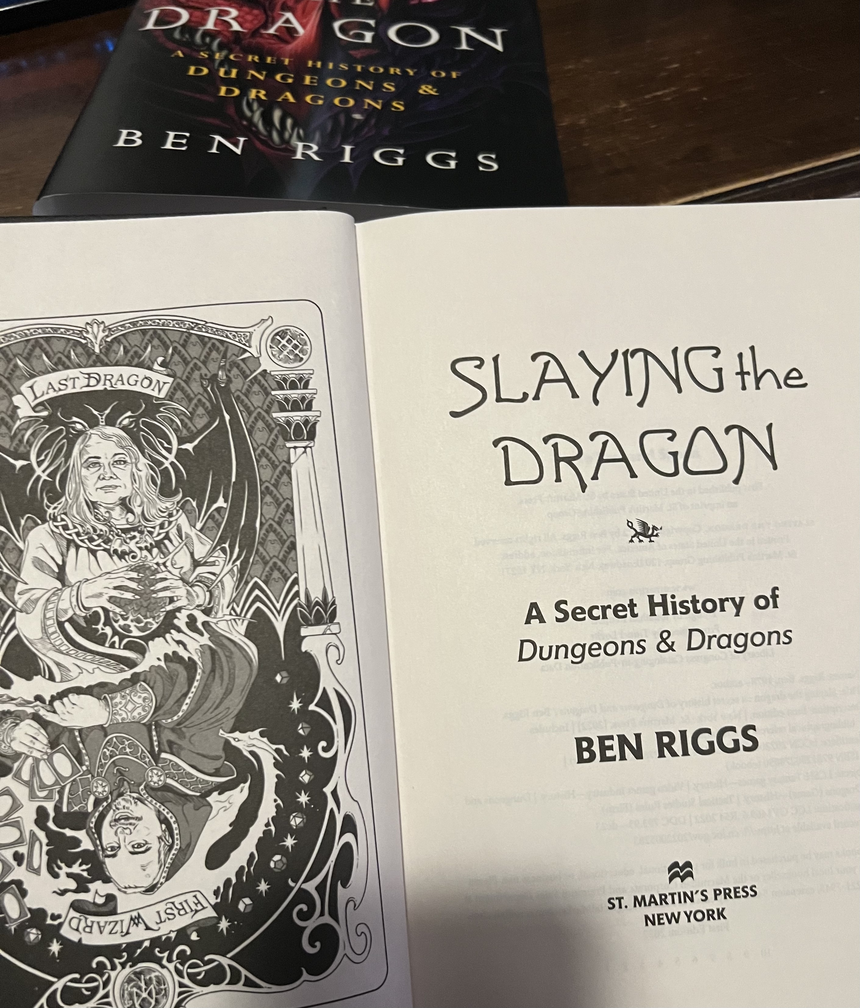 Ben Riggs book: Slaying the Dragon. With an illustration in the inside title page of Lorraine Williams as the top half of a playing card labeled, Last Dragon, and Peter Adkinson on the flip side labeled, First Wizard. Slaying the Dragon a book by Ben Riggs from St. Martin Press.