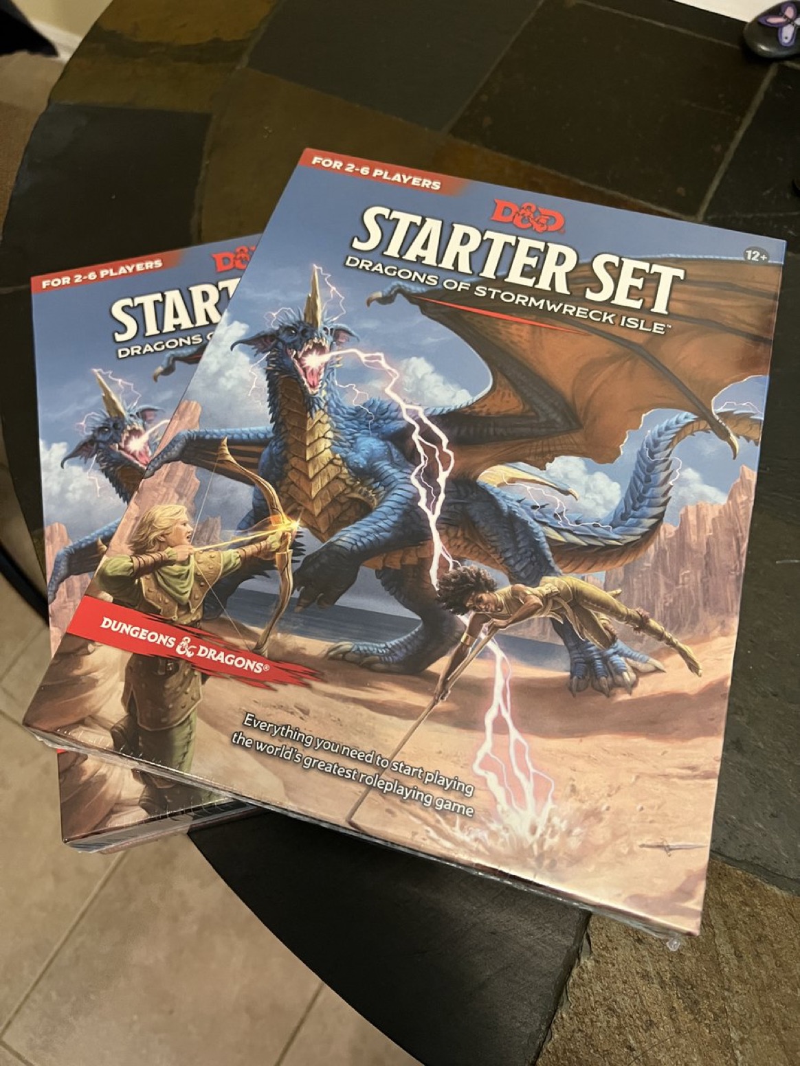 Photo of the first book and the box, nice art of PCs fighting a blue dragon 