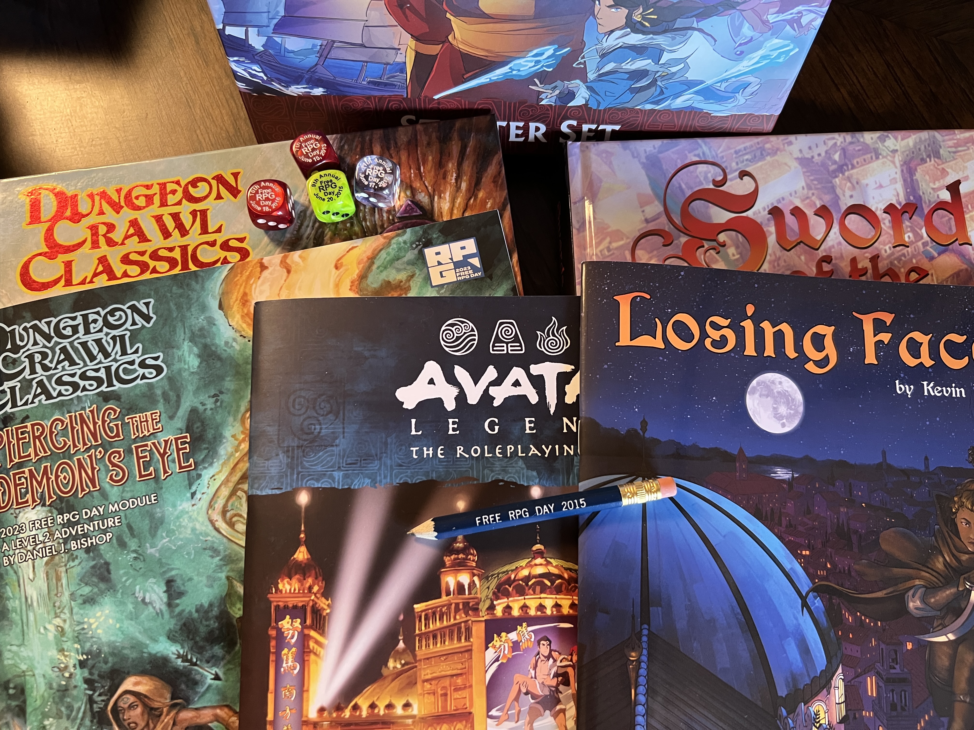 Sword of the serpentine and it’s core book. DCC and it’s core book. Avatar the last airbender and it’s starter box. Plus free rpg day dice going back to 2013 and a 2015 pencil.