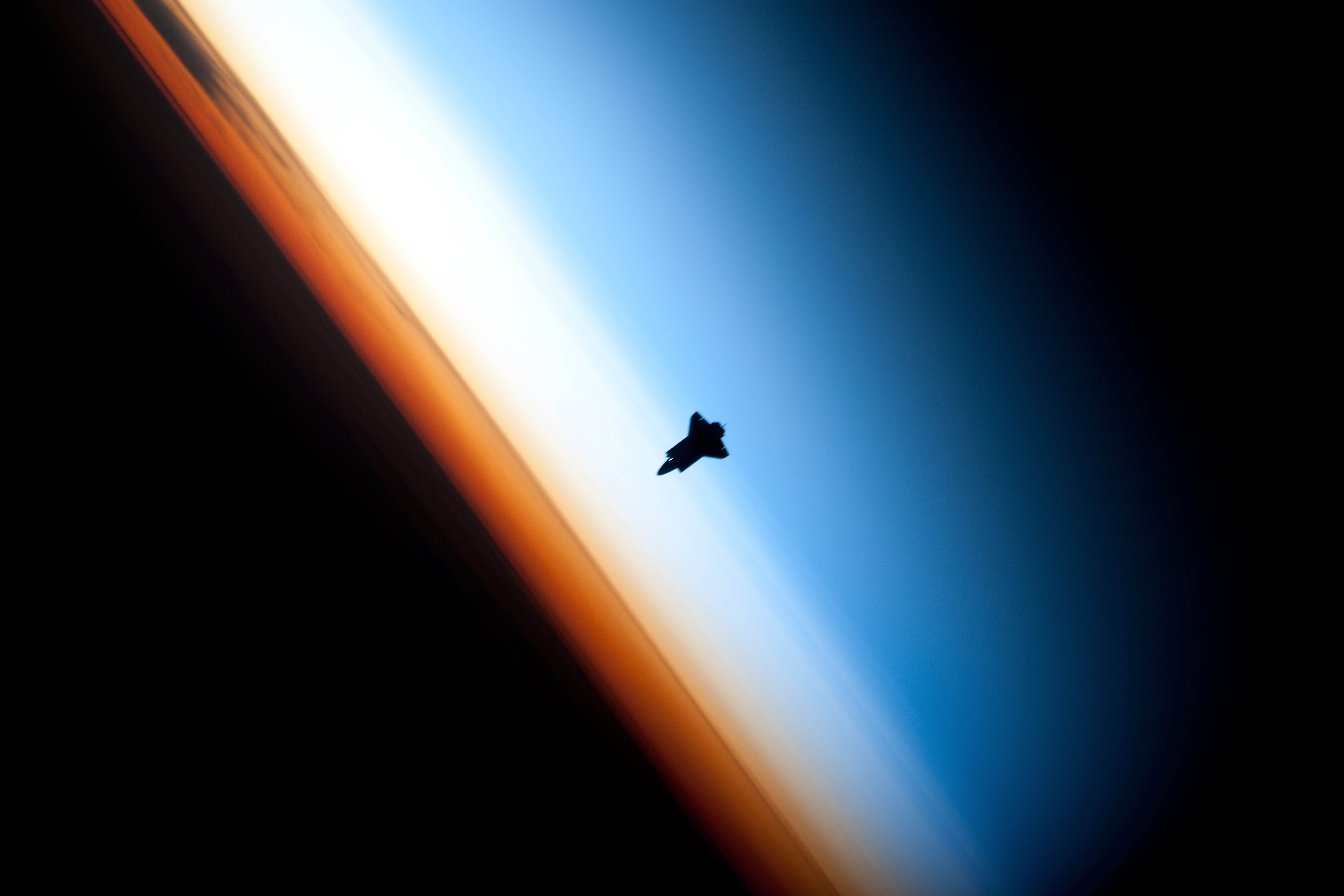 Shuttle between pure cyanish mesosphere and hazy yellowish stratosphere, above orange troposhere.jpg